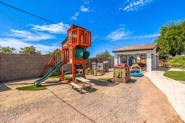 a view of a backyard with table and chairs under an umbrella