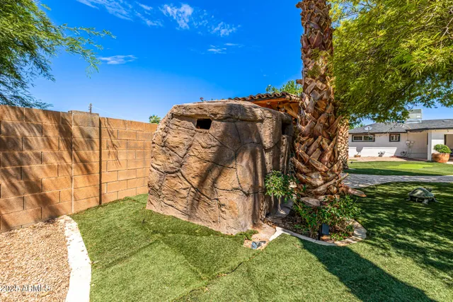 a couple of palm trees sitting in a yard next to a house