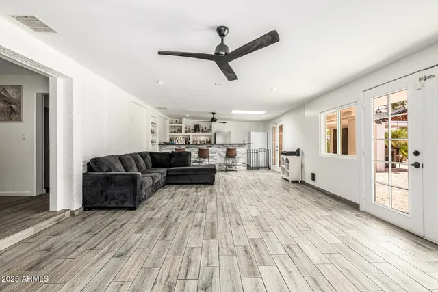 a kitchen with stainless steel appliances granite countertop a stove top oven a dining table and chairs with wooden floor