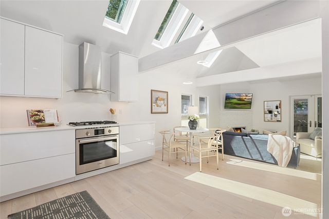a kitchen with stainless steel appliances granite countertop a stove and white cabinets