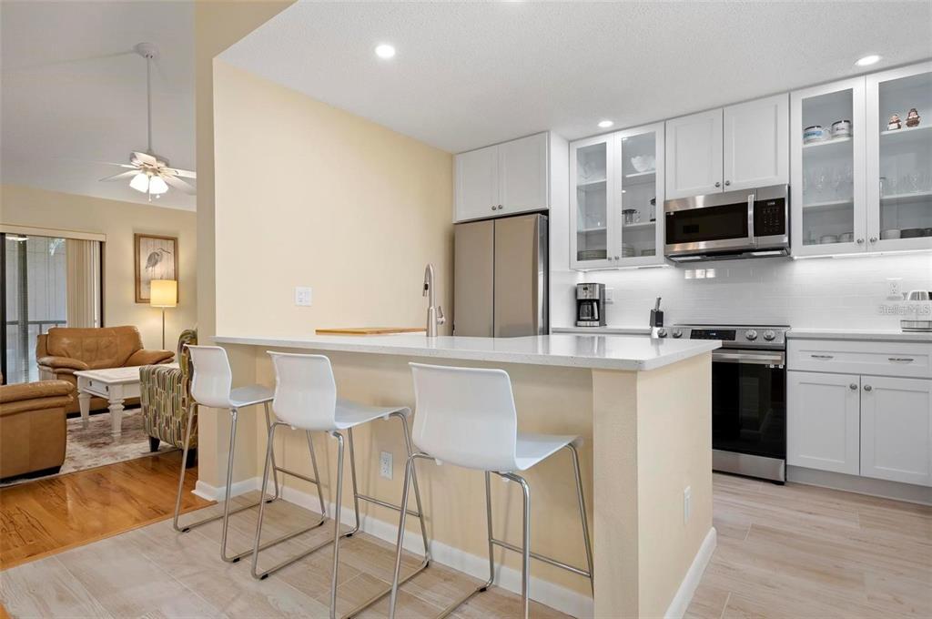 1707 Pelican Cove Road, Unit 451 Sarasota, FL 34231 - Photo 5 of 24 a kitchen with stainless steel appliances a stove a sink refrigerator and microwave