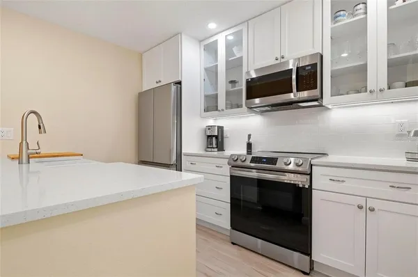 a kitchen with stainless steel appliances a stove microwave and sink
