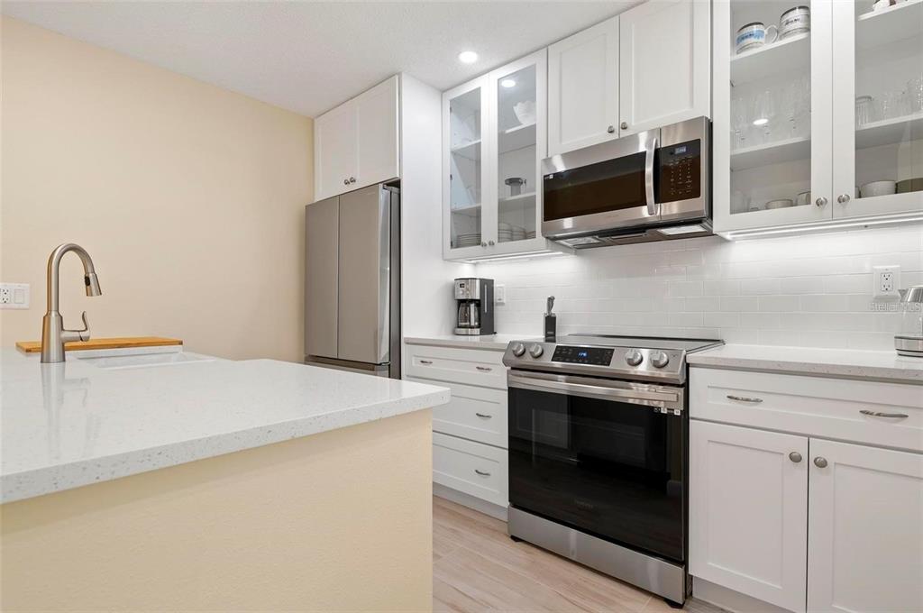 1707 Pelican Cove Road, Unit 451 Sarasota, FL 34231 - Photo 6 of 24 a kitchen with stainless steel appliances a stove microwave and sink