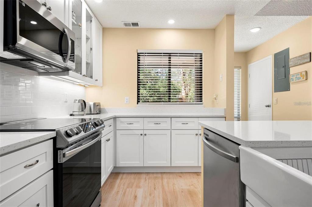 1707 Pelican Cove Road, Unit 451 Sarasota, FL 34231 - Photo 7 of 24 a kitchen with stainless steel appliances granite countertop a sink stove and microwave