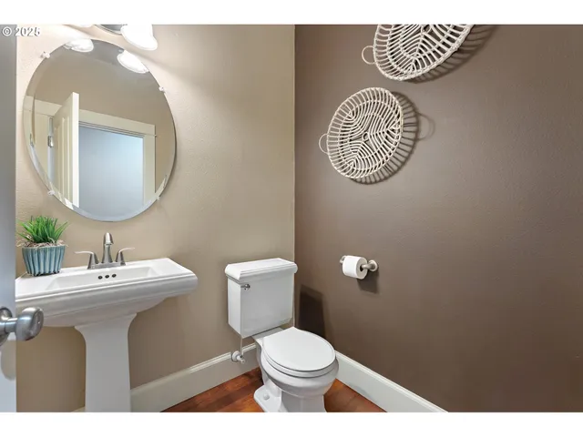 a bathroom with a toilet sink vanity and mirror