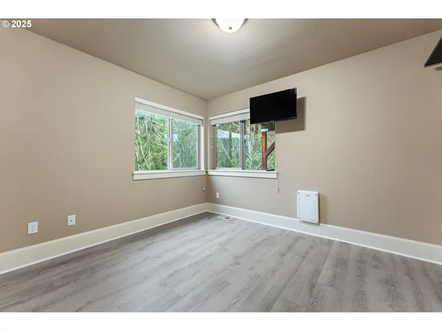 a view of room with window flat screen tv and wooden floor