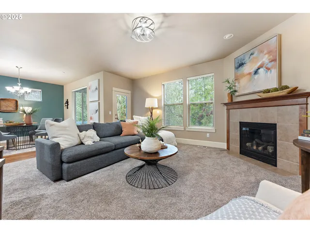 a living room with furniture a fireplace and a large window
