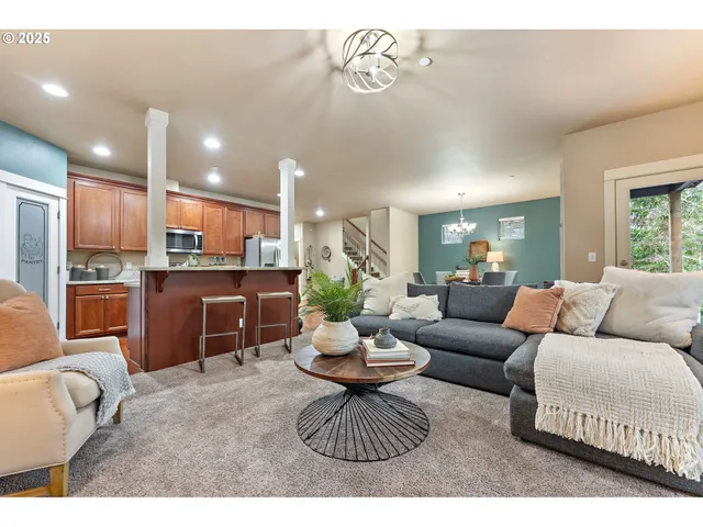 a living room with furniture a rug and kitchen view