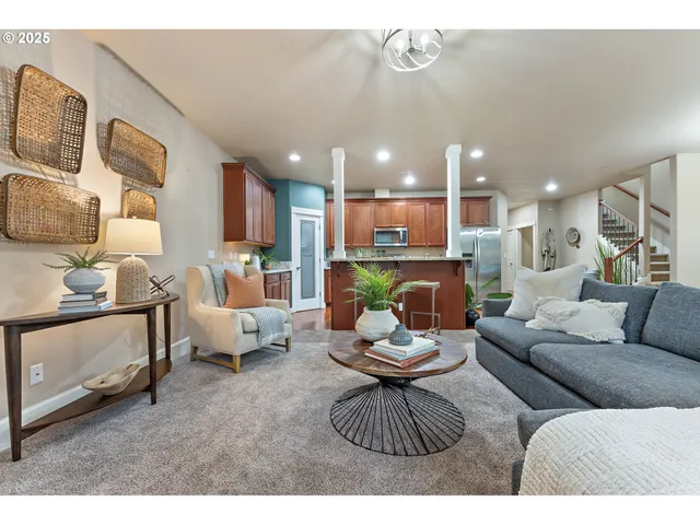 a living room with furniture and a view of kitchen