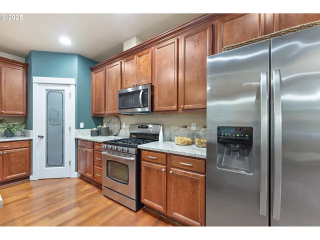 a kitchen with stainless steel appliances granite countertop a refrigerator a stove top oven a sink and dishwasher
