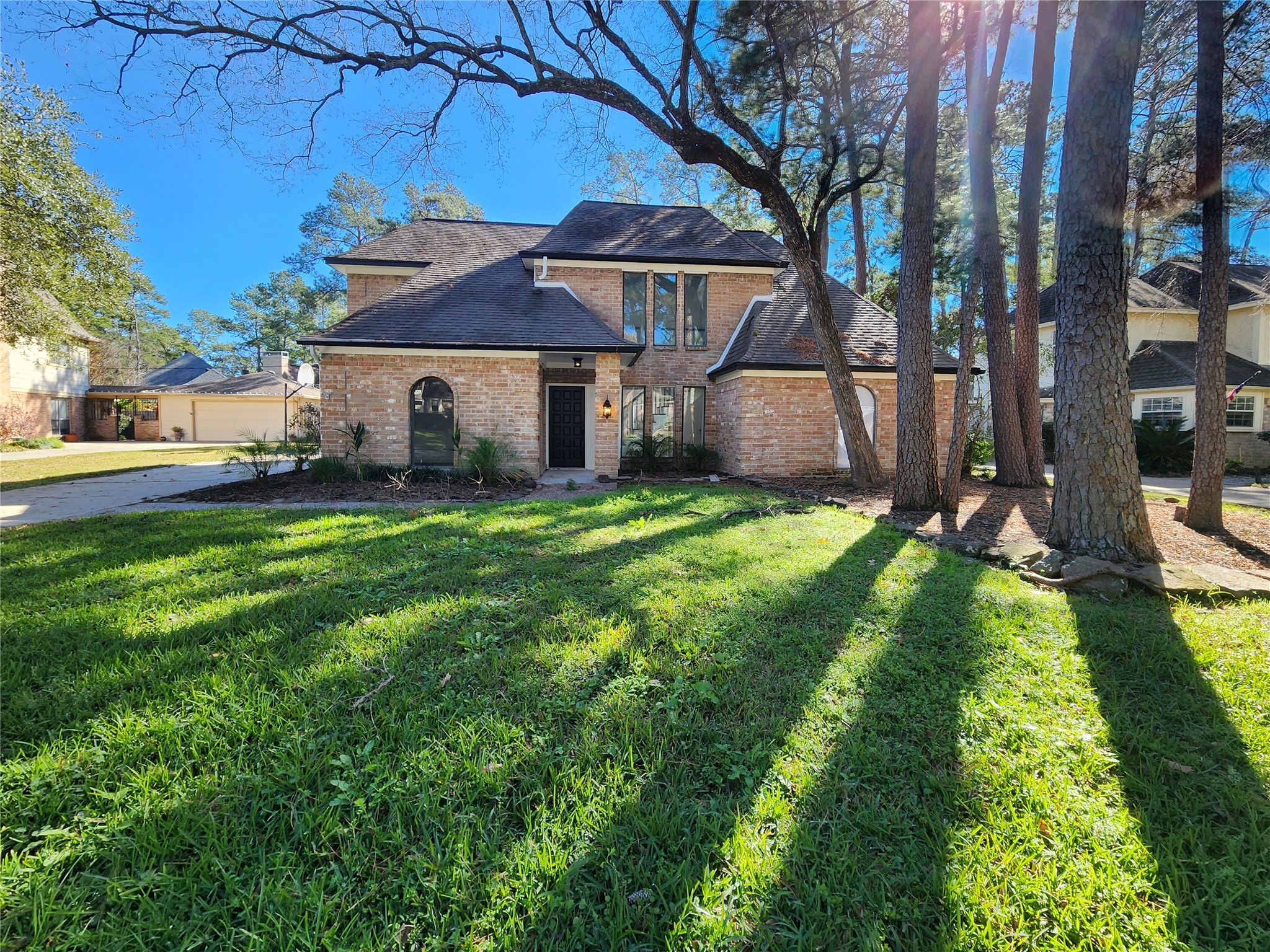 a view of a house with a yard and large tree
