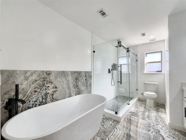 an empty room with a window and a chandelier fan