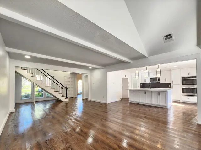 a view of a living room and kitchen with furniture wooden floor and window