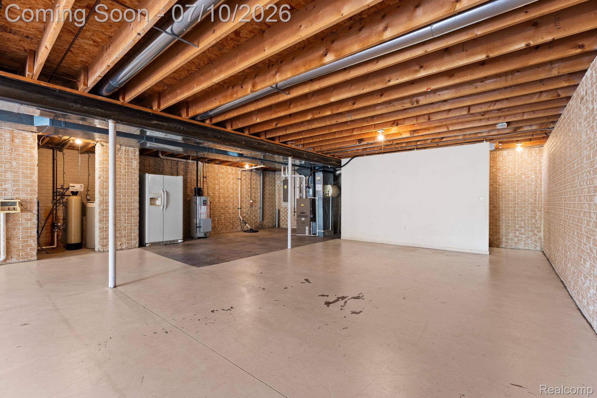 3144 North Nicholson Road Fowlerville, MI 48836 - Photo 64 of 70 Expansive unfinished basement featuring an exposed wood ceiling, concrete flooring, and brick-patterned walls
