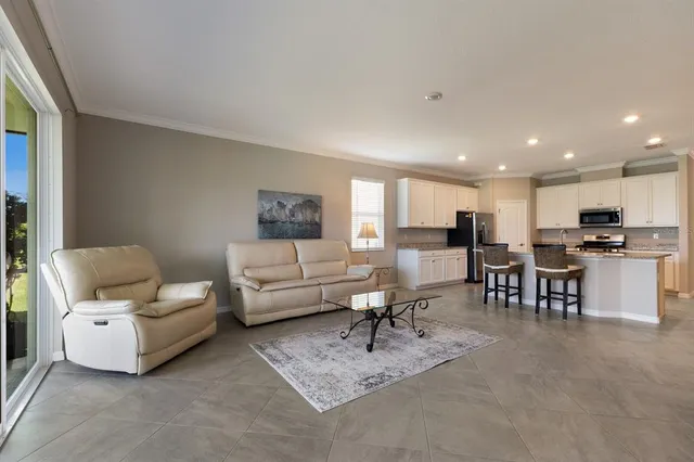 a living room with furniture and view of kitchen