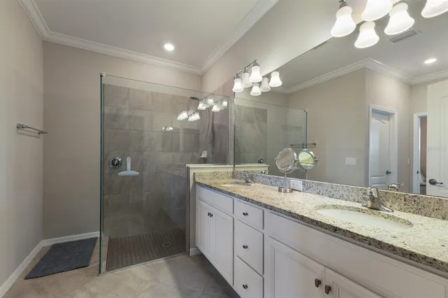 a bathroom with a granite countertop double vanity sink and a mirror