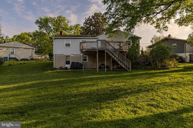 a view of a house with a big yard and large trees