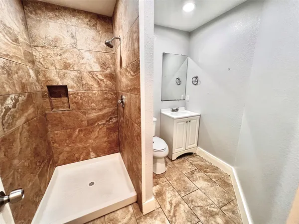 a bathroom with a sink a toilet and shower