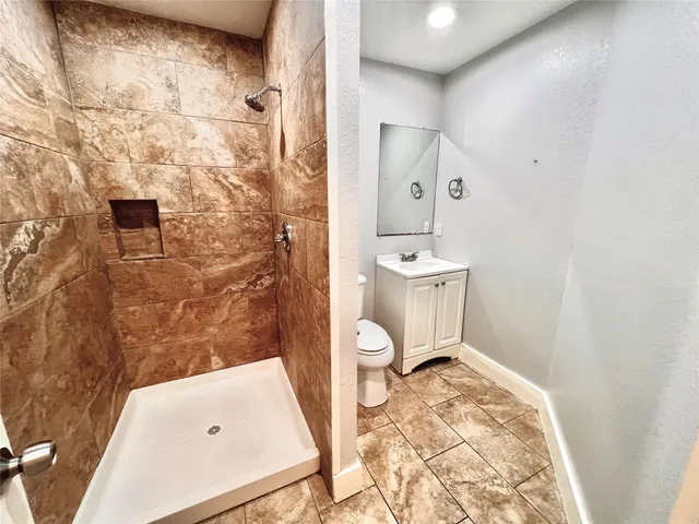 a bathroom with a sink a toilet and shower