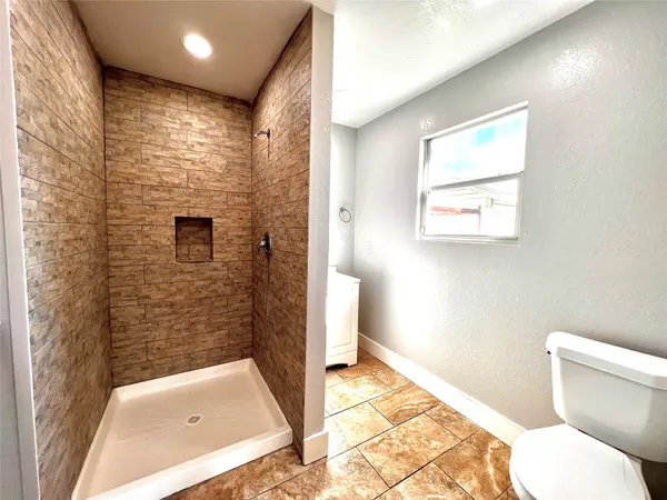 a bathroom with a toilet and a shower