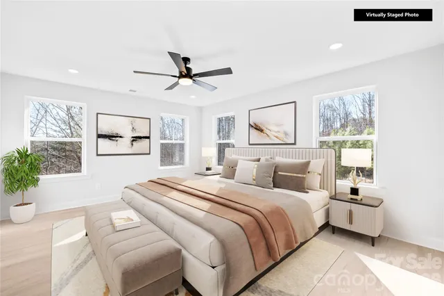 a bedroom with a large bed and a chandelier