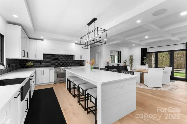 a large kitchen with kitchen island a sink table and chairs