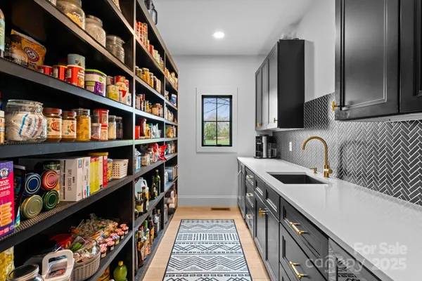 a kitchen with stainless steel appliances granite countertop a lot of cabinets and a wooden floor