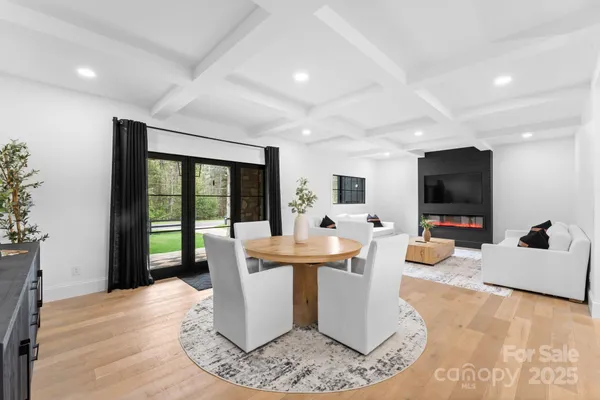 a dining room with a large window and living room view