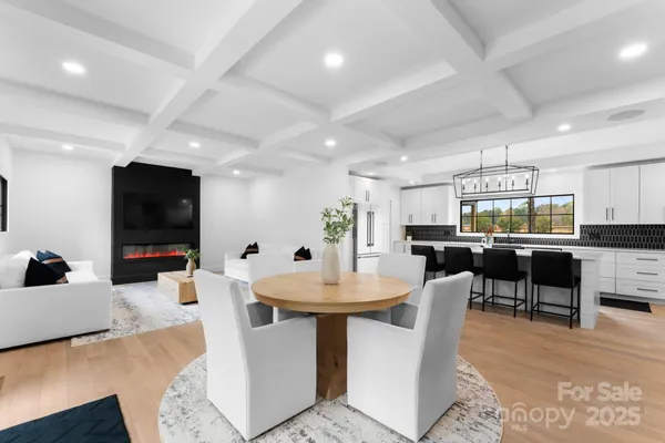 a dining room with kitchen island furniture a chandelier and a flat screen tv