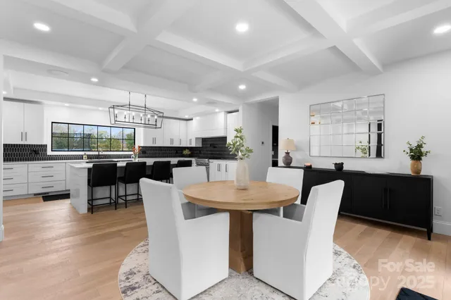 a dining room with stainless steel appliances kitchen island granite countertop a dining table chairs and a refrigerator