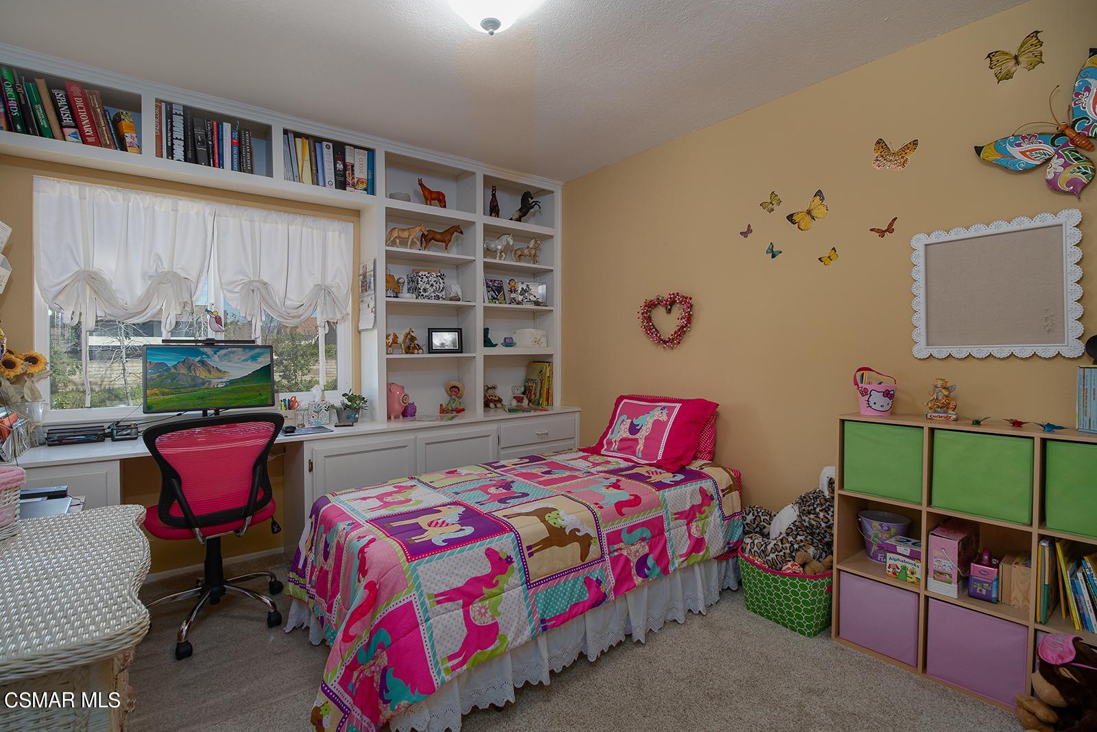 13339 Peach Hill Road Moorpark, CA 93021 - Photo 21 of 45 a bedroom with a bed a book shelf and a shelf