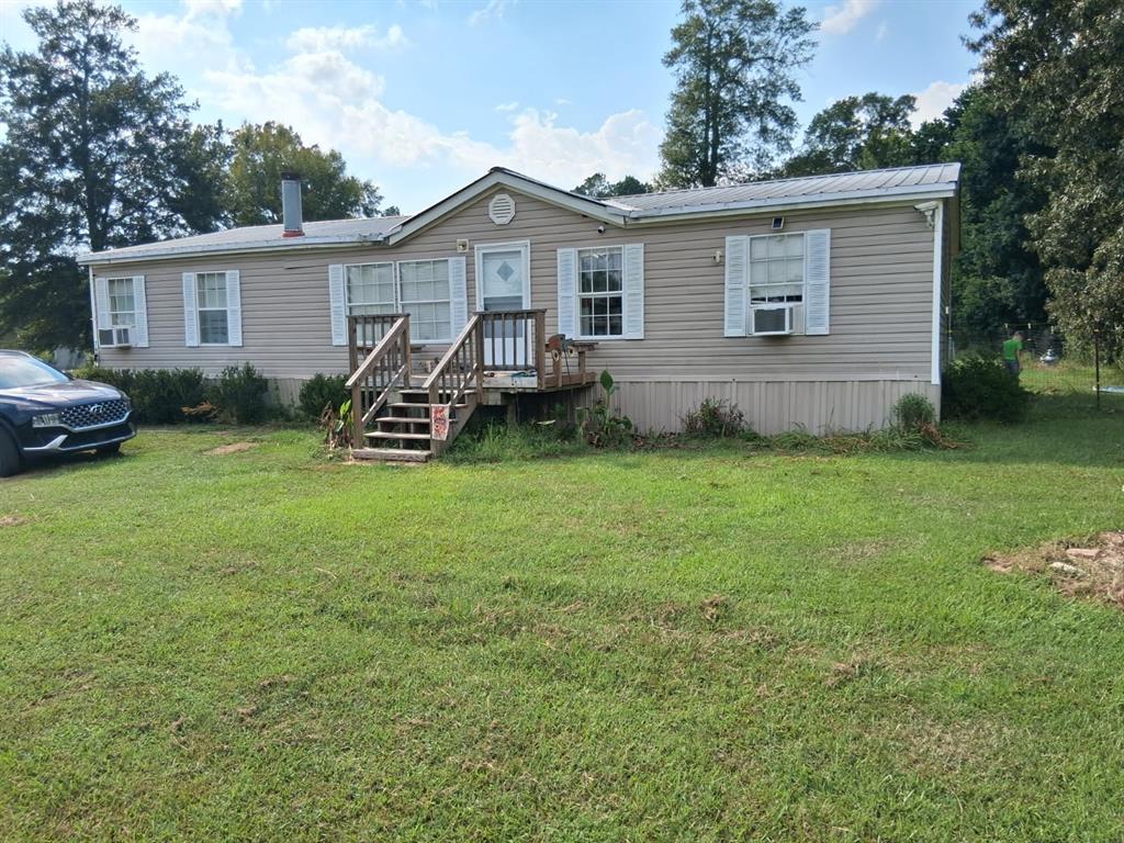 a view of a house with a yard and sitting area