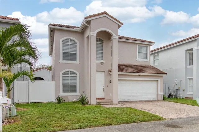 a front view of a house with a garden and yard