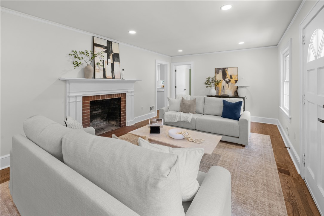 Rich hardwood flooring and a classic brick fireplace anchor this comfortable living room.