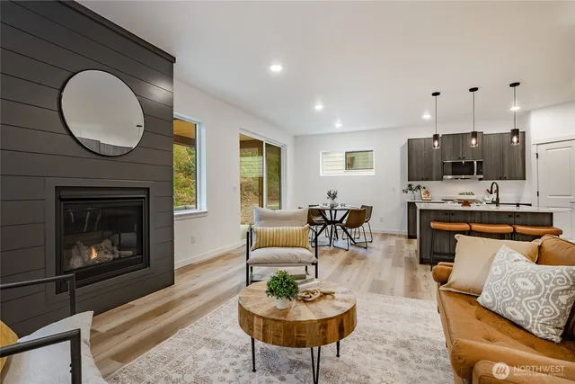 a living room with furniture a fireplace a rug and a window
