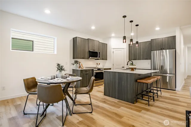 a kitchen with a table chairs refrigerator and a microwave