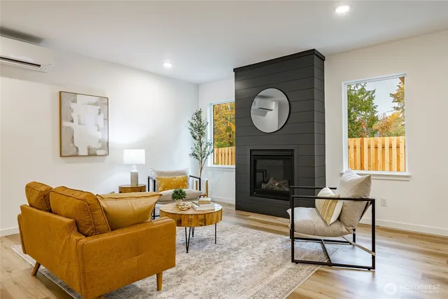 a living room with furniture a clock and a fireplace