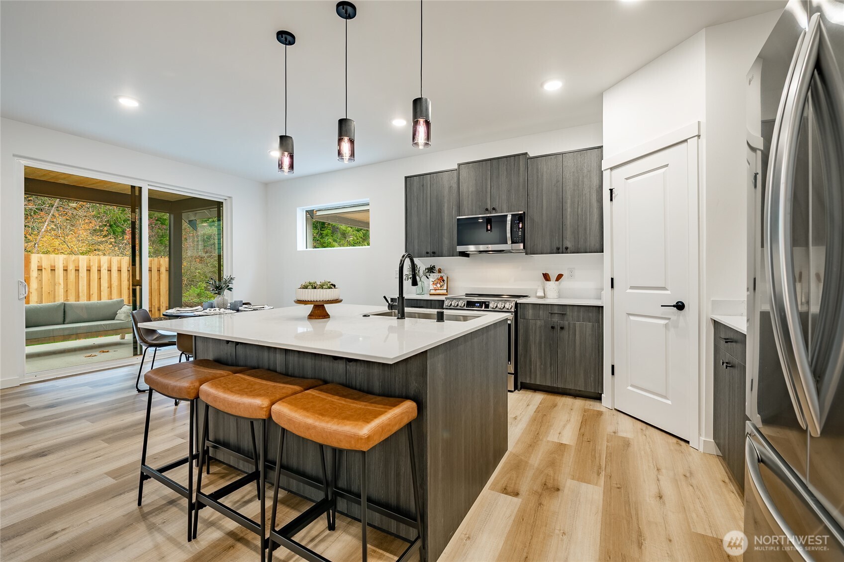 2992 Cedar View Road Blaine, WA 98230 - Photo 9 of 39 a kitchen with stainless steel appliances granite countertop a sink a stove a refrigerator cabinets and a dining table with wooden floor