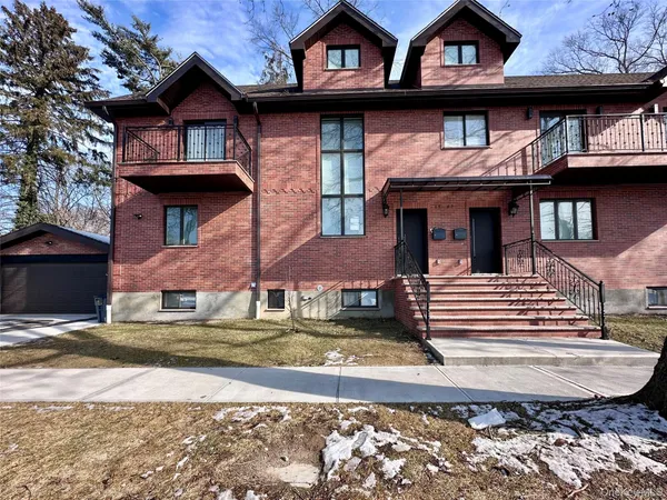 a view of a brick house with large windows