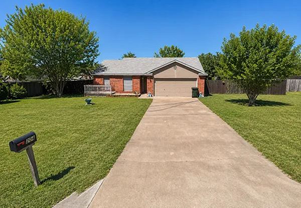 a front view of a house with a yard and trees