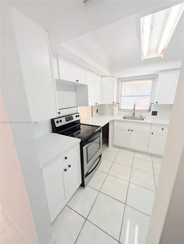 a kitchen with a sink a stove and cabinets
