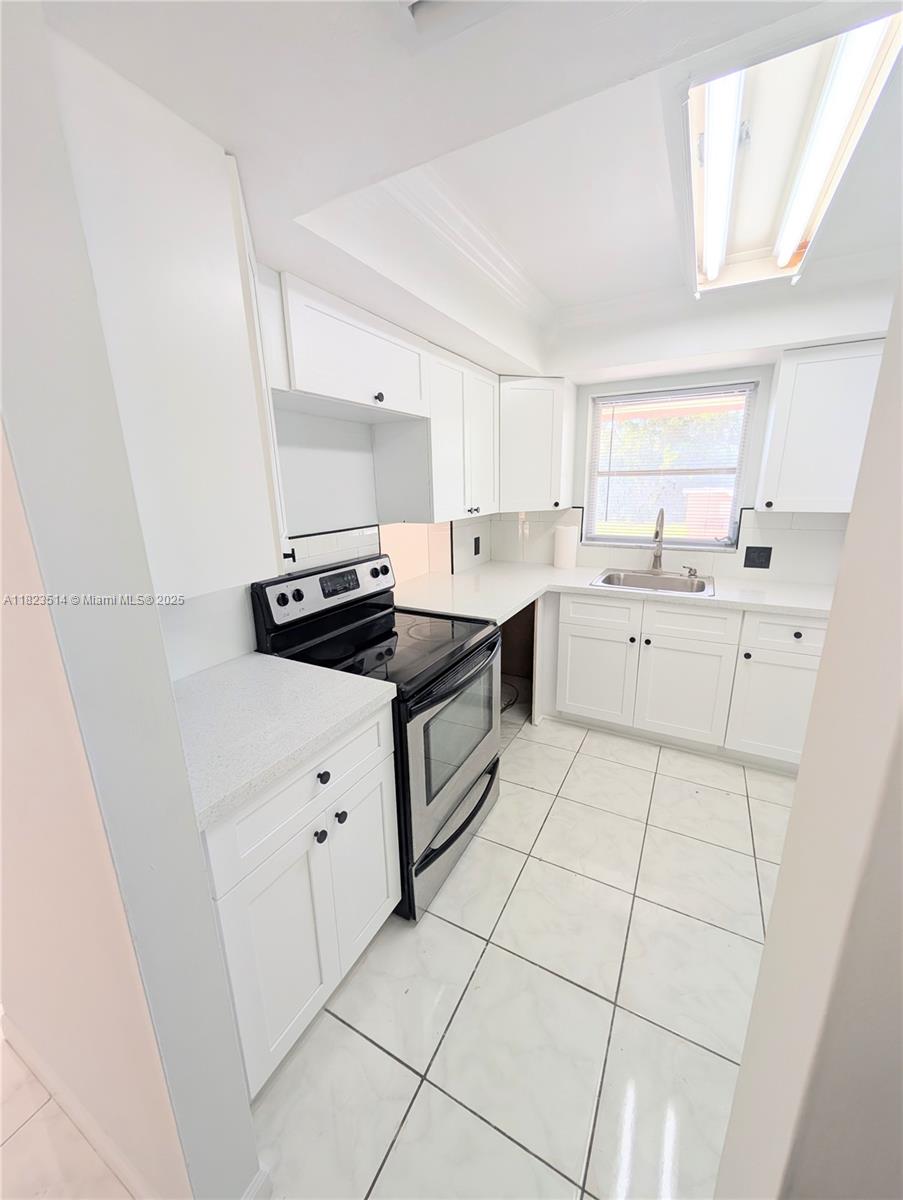 14901 Southwest 4th Street, Unit 9A Pembroke Pines, FL 33027 - Photo 1 of 35 a kitchen with a sink a stove and cabinets