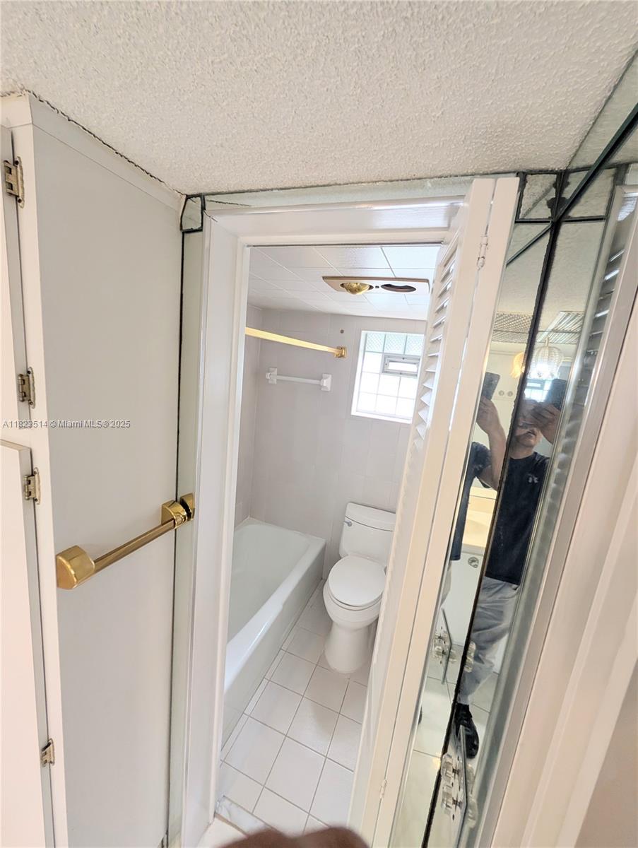 14901 Southwest 4th Street, Unit 9A Pembroke Pines, FL 33027 - Photo 18 of 35 a bathroom with a granite countertop shower and a toilet