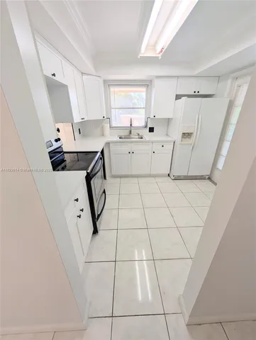 a living room with white cabinets and appliances