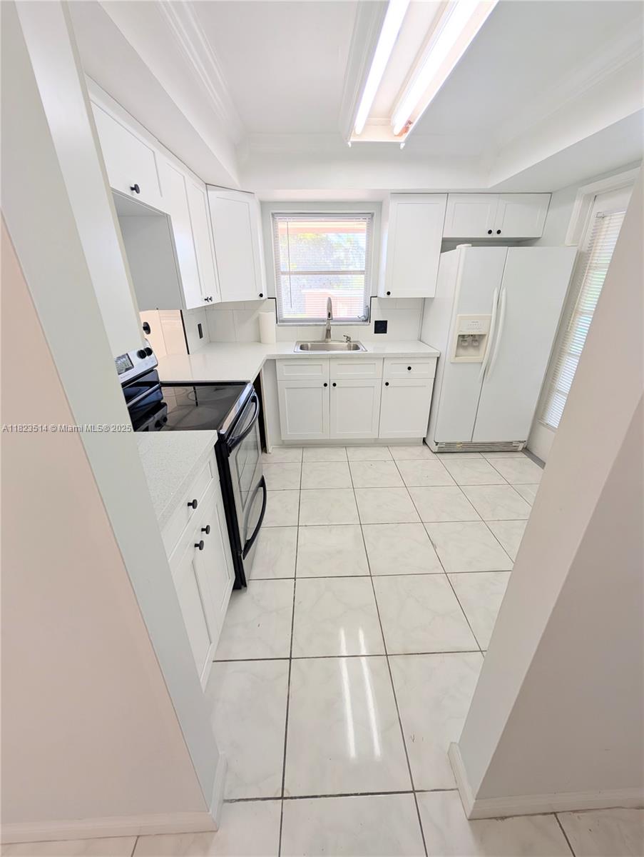 14901 Southwest 4th Street, Unit 9A Pembroke Pines, FL 33027 - Photo 2 of 35 a living room with white cabinets and appliances