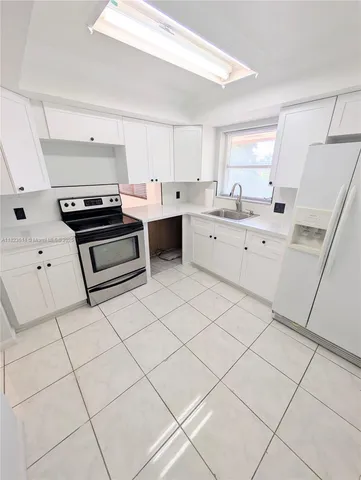 a kitchen with a stove a sink and a refrigerator