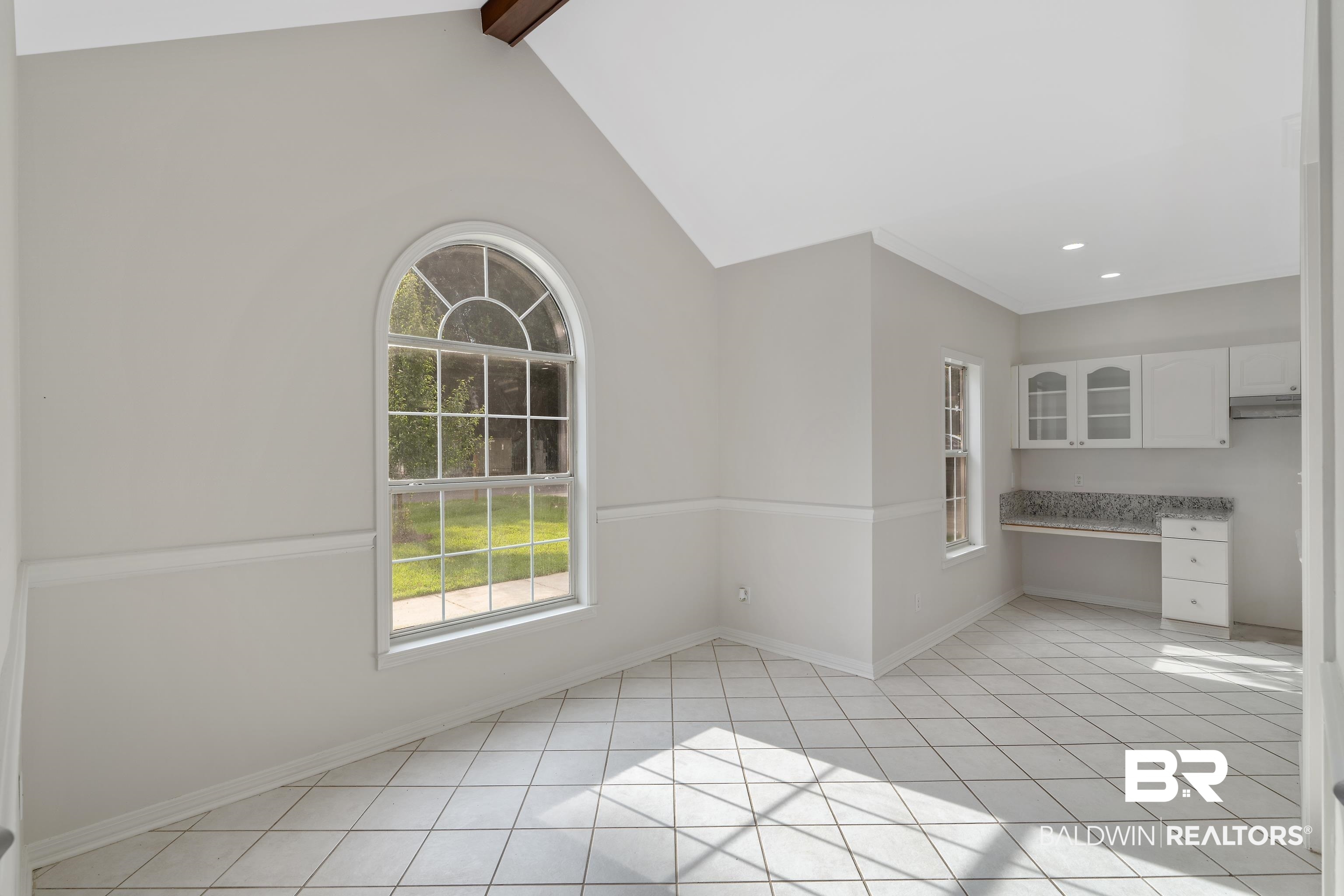 20525 Lawrence Road Fairhope, AL 36532 - Photo 7 of 26 Breakfast/ dining space featuring light tile patterned floors, vaulted ceiling with beams, and built in desk