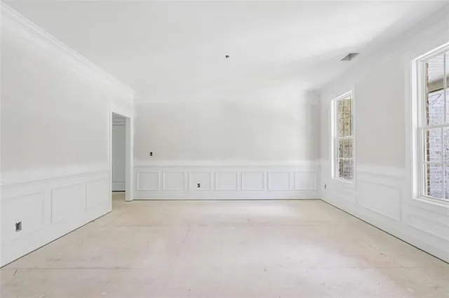 an empty room with white walls and windows