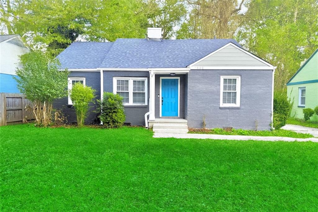 a front view of a house with a yard and green space