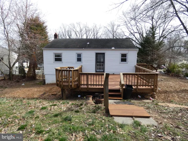 a view of a house with wooden deck and furniture